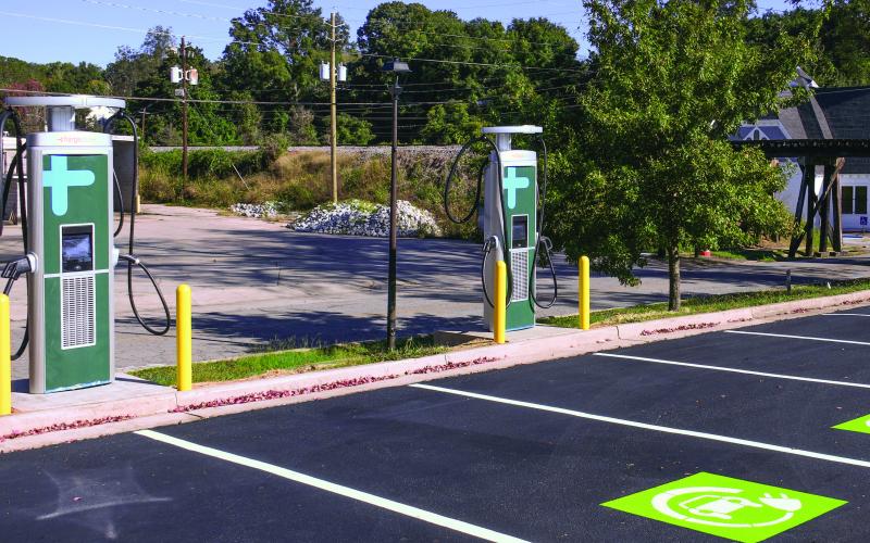With downtown Eatonton’s historic train trestle and Ebeneezer Baptist Church in the background, brand-new EV charging stations installed alongside Willie Bailey Drive await final approval and activation through Georgia Power, expected to come within the next month. IAN TOCHER/Staff