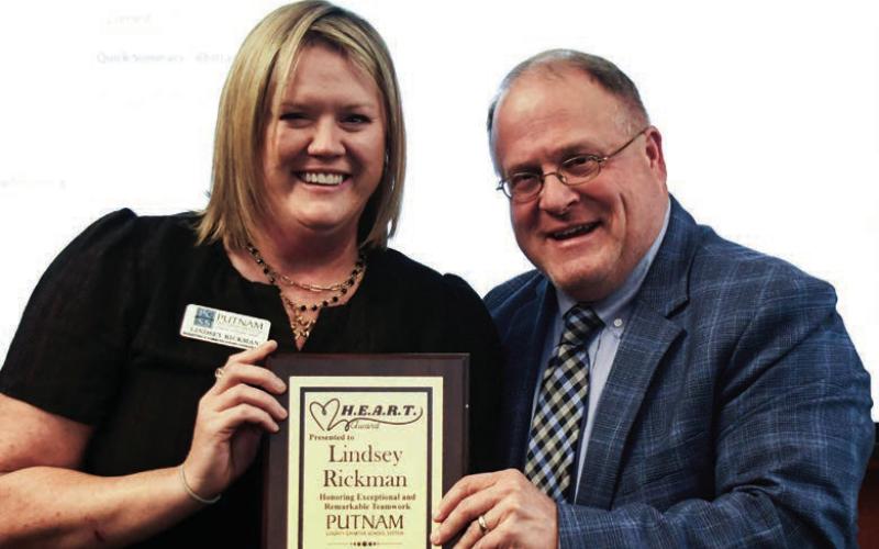 Putnam County Charter School System communications specialist Lindsey Rickman accepted the school board’s Honoring Exceptional and Remarkable Teamwork (HEART) award Oct. 19, from Assistant Superintendent Scott Sauls at Rock Eagle’s convention center. IAN TOCHER/Staff
