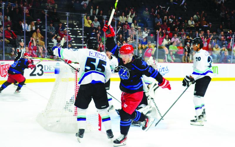 Garret Milan (center) of the Rock Lobsters celebrates after scoring on Mississippi goalie Edward Coffey in the first period of the two teams’ New Year’s Eve game at Akins Ford Arena in Athens. IAN TOCHER/Staff