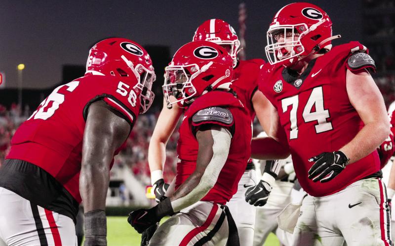 Georgia offensive lineman celebrate with running back Trevor Etienne (center). COURTESY OF UGA ATHLETICS