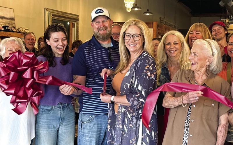 Surrounded by friends and family, Kirtsten Thompson (with scissors) officially opened her new store, Saving Grace, with a ribbon-cutting ceremony hosted last Saturday by the Eatonton-Putnam Chamber of Commerce. CONTRIBUTED