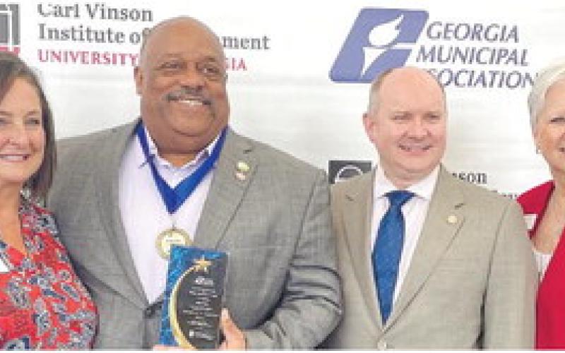 Eatonton Mayor John Reid (second from left) was all smiles after receiving high praise and recognition June 26, during the Georgia Municipal Association’s annual convention in Savannah. CONTRIBUTED