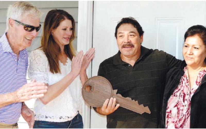 Putnam County Habitat for Humanity Board President Bucky Kahl and Jennifer Ishee, a member of the Habitat Family Selection Committee, present a ceremonial key Nov. 1, to new homeowners Alfredo and his wife, Gloria. IAN TOCHER/Staff