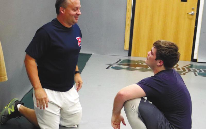 Coach Hutsell give tips on technique to Senior Tristan Lower. ARELLA CASH/Staff