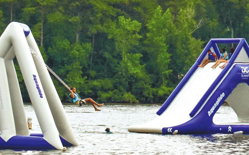 People are having a blast on inflatables on water.