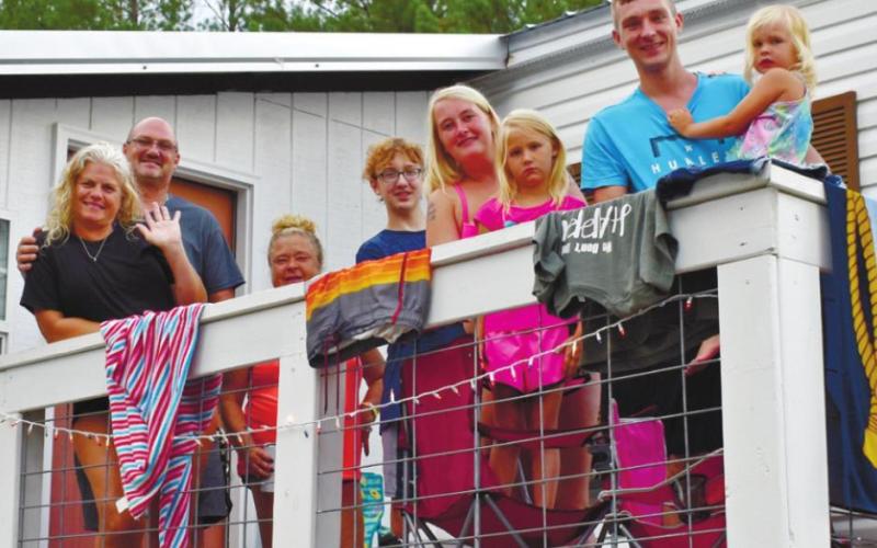 The Campbell and Nunley families pose for a photo near the cabin.