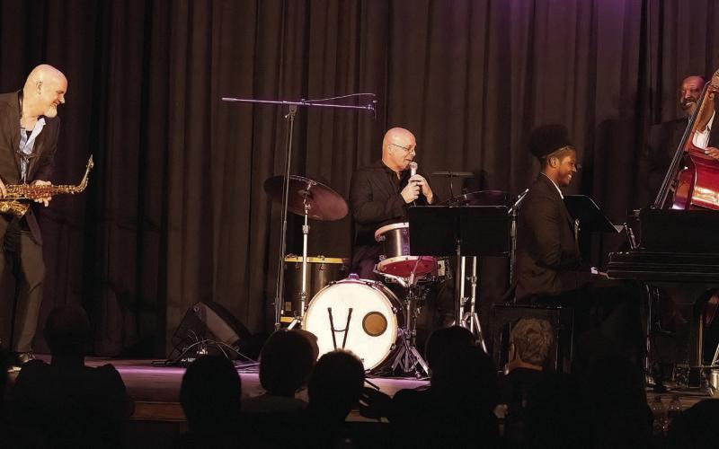 All smiles as drummer Justin Varnes of The Jazz Legacy Project describes the music of Charlie Parker to Festival Hall patrons.