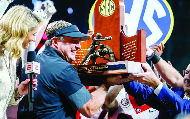 Georgia head coach Kirby Smart holds up the 2025 SEC Championship trophy after the Bulldogs knocked off Alabama 28-7 at Mercedes-Benz Stadium Dec. 6. LANCE MCCURLEY/Staff