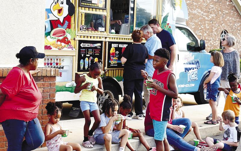 National Night Out attendees cool off eating flavored, shaved ice from the on-site Kona Ice vendor.