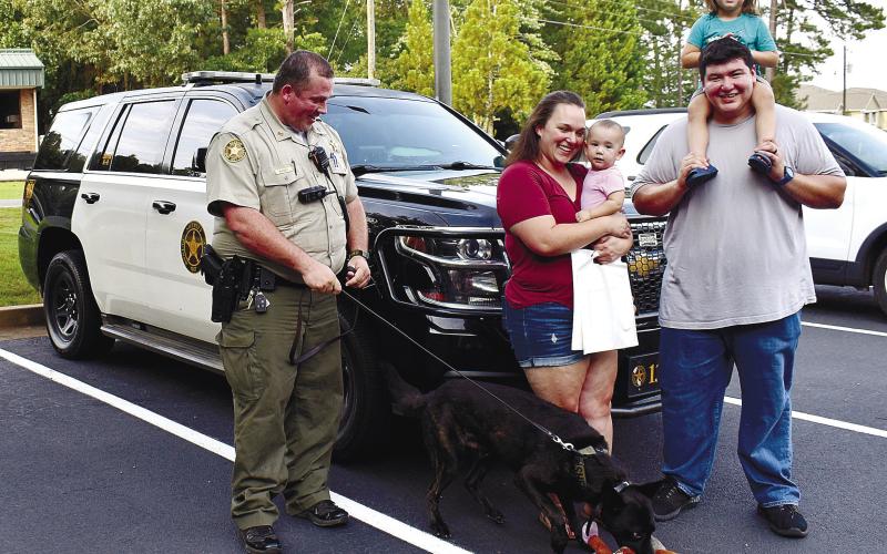Posing with K9 “Storm,” are Deputy Alex Rickey, Shelby Flores with baby Mateo Flores, and Alfred Flores with daughter Lucy Flores.