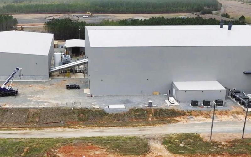 These buildings built deep on the approximately 3,200 acres of Plant Branch will provide indoor storage (left) for huge piles of coal ash before transferring to the larger building via enclosed augers (diagonal tubes) for treatment of the ash before shipping via rail cars to various concrete manufacturing plants. COURTESY GEORGIA POWER