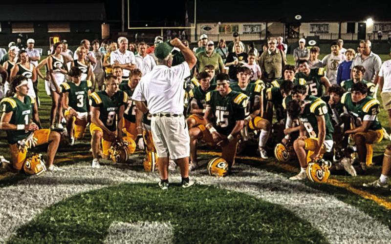 Early this season, Gatewood head coach Jeff Ratliff (center) held court with his players, cheerleaders, and parents of both near the 50-yard line at Sammons Field in Eatonton. IAN TOCHER/Staff