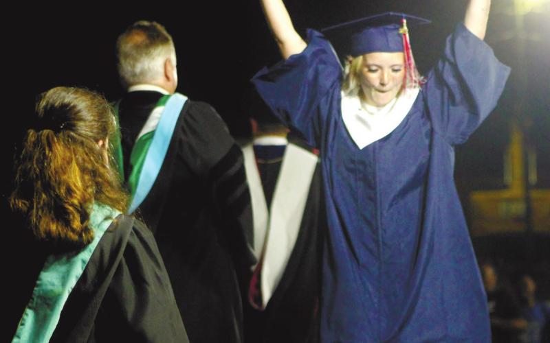Trinity Williams celebrates receiving her diploma as she walks off the stage.