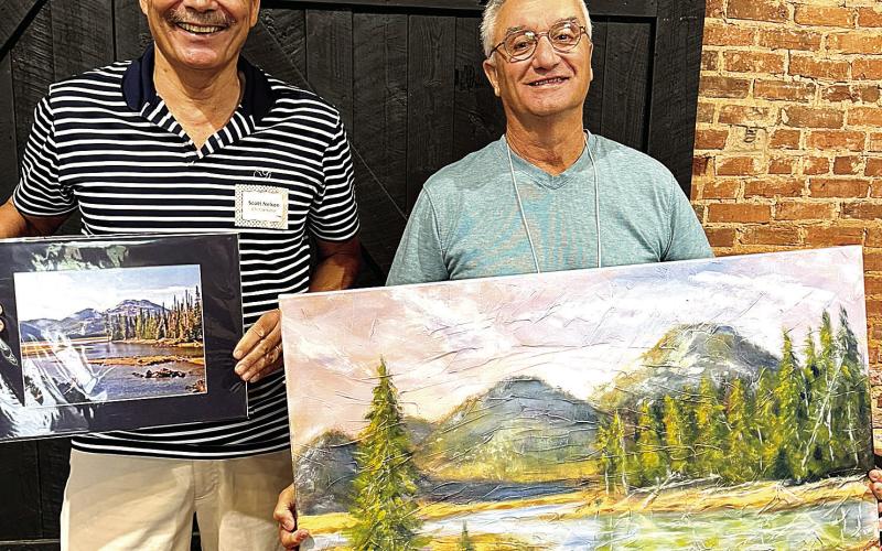 Photographer Scott Nelson (left) with “Oregon Trail” stands with artist Frank Cassara, who painted “Oregon Mountain Splendor.” CONTRIBUTED