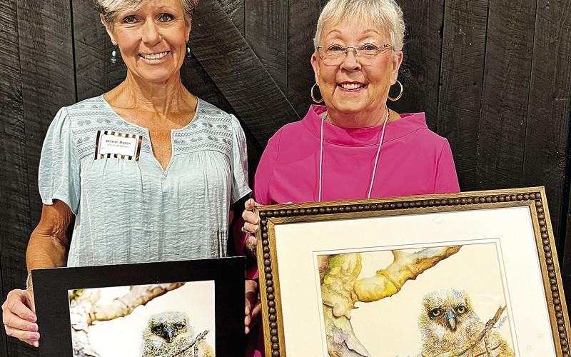 Photographer Diane Byers (left) holds her photo “Diane’s New Neighbor” alongside artist Madelyn Wharton and her “Owlet with Golden Eyes.” CONTRIBUTED
