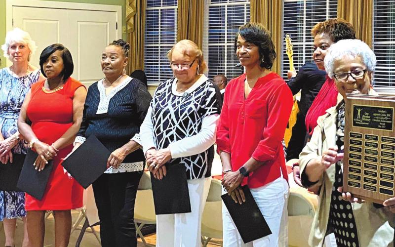 The Rev. Walter Milner presents Georgia Smith and the other members of Mothers Against Crime with the Christian Achievement Award. HANK SEGARS/Staff