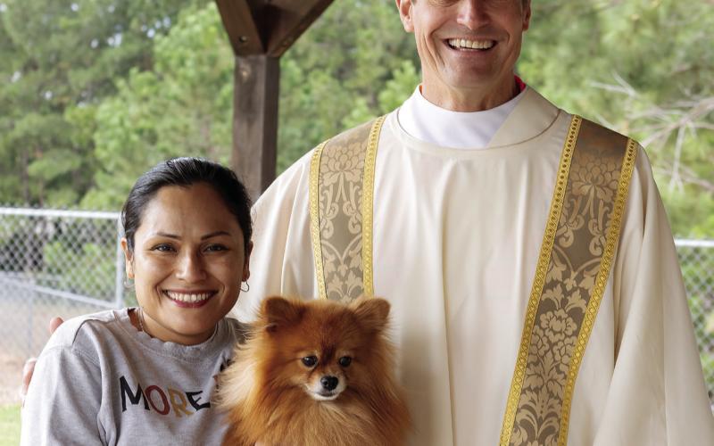 Rev. Stephen Pond with Sandra Morales and her Pomeranian Boris. LEIGH LOFGREN/Staff