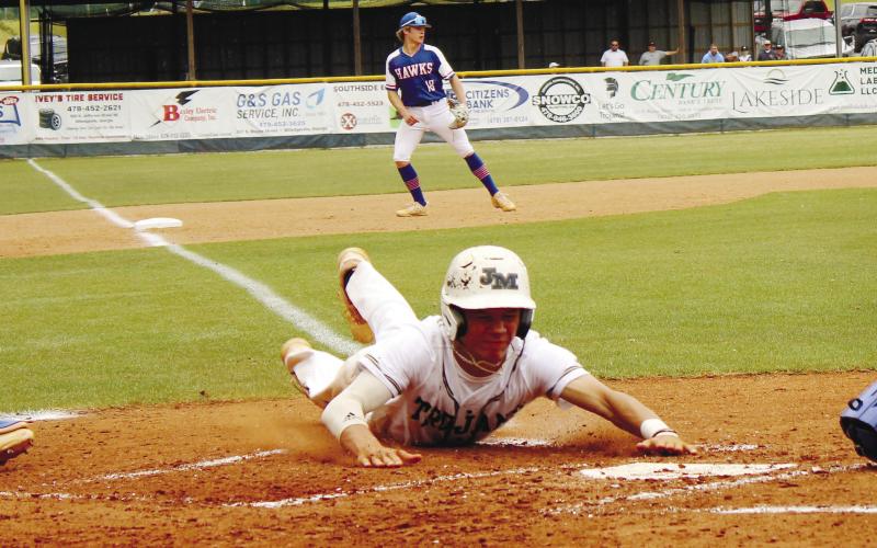 Junior Cooper Wilburn (7) slides headfirst into home plate to contribute to the Trojans’ 12-8 win that advanced them to the GIAA Class AAA semifi nals. TREY NORRIS/Staff