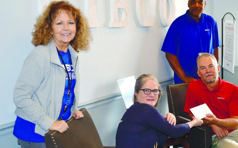 Plant manager at NIBCO Douglas Purnell (right seated) presents Festival Hall Director Nicole Chillemi (left seated) with a $500 sponsorship check. CONTRIBUTED