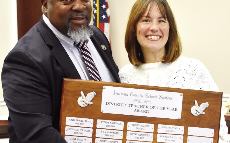 District Teacher of the Year Sharon Creek, alongside Superintendent Derick Austin, holds up the Teacher of the Year plaque, where her name will soon be engraved. BAILEY BALLARD/Staff