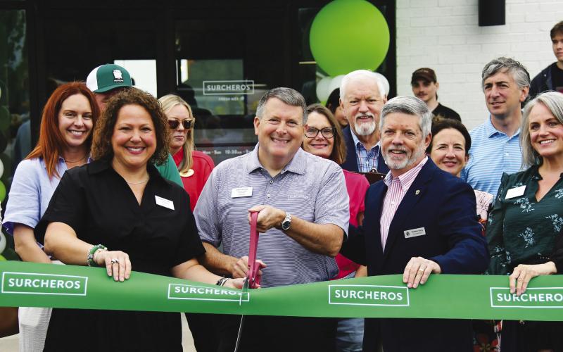 With his wife, Debbie, and Eatonton-Putnam Chamber of Commerce President Robbie King alongside, restaurateur Kyle Cullars prepare to cut the ribbon for his family’s third Surcheros franchise, with a fourth coming soon in Perry. IAN TOCHER/Staff