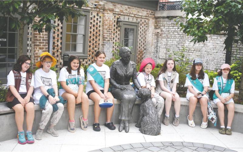 Posing with a statue of Girl Scouts of the USA founder Juliette Gordon Low in the front yard at Low’s birthplace in Savannah, are members of Girl Scouts of Eatonton (l-r): Zoey Robinson, Elizabeth Hensley, Karmen Spillers, Sophia Talavera, Victoria Hensley, Raegan Ogden, Tegan Rainey, and Stormy Kendrick. LENA HENSLEY/Staff