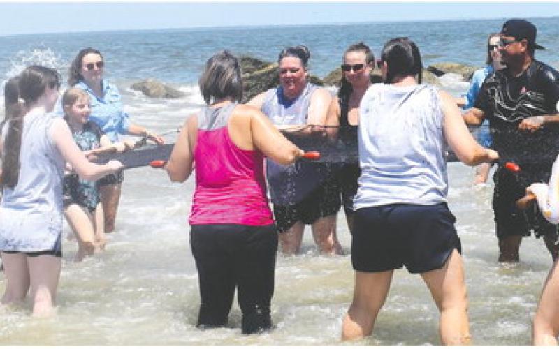 The girls and their parents are seining – catching fish with a net – into the waves that sweep you off your feet leaving no chance to remain fully dry. The group caught two fish, which were released back in the ocean. LENA HENSLEY/Staff