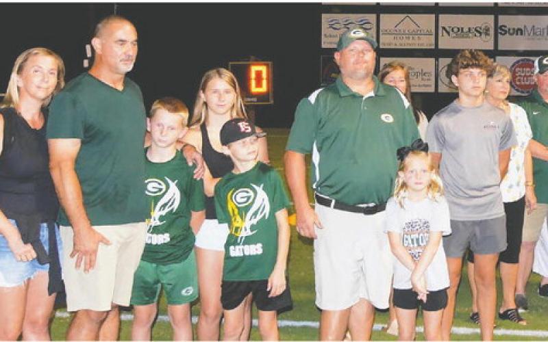 Chris Daniluk (second from left) and Clyde Harper (sixth in line) gathered with their families and friends at halftime during the Gatewood football game last Friday night, where the practice facility they built for the school was dedicated in memory of Harper’s nephew, Walt Harper. CONTRIBUTED