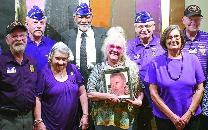 Members of the Athens-based John W. Hancock Memorial Chapter 531 of the Military Order of the Purple Heart pose with the daughter of Charlie Bonner Award for Advancing Education winner Richard “Ole” Olsen, holding a photo of her father. IAN TOCHER/Staff