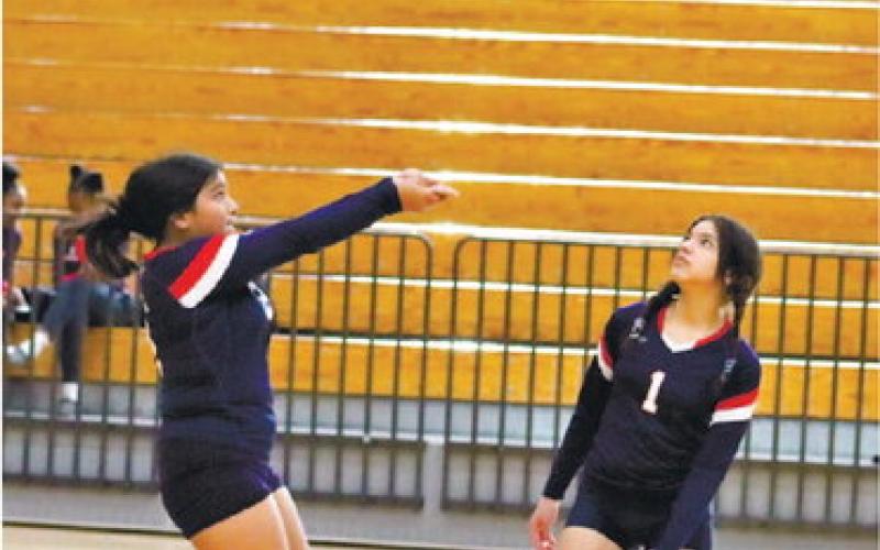 Regina Espin with a save for the Lady Eagles as Jazmine Sepulveda (1) looks on.