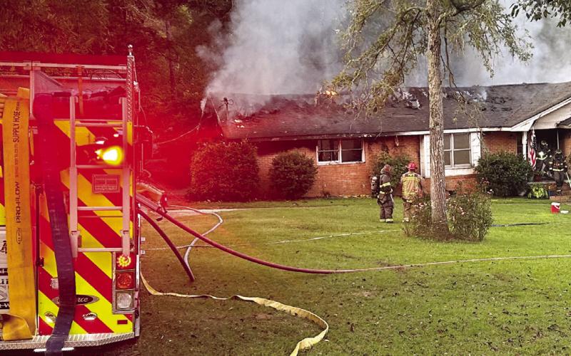 Smoke and flames can be seen on the back of the house as City of Eatonton and Putnam County firefighters begin to battle the blaze. CHIEF WILLIAMSON/Contributed