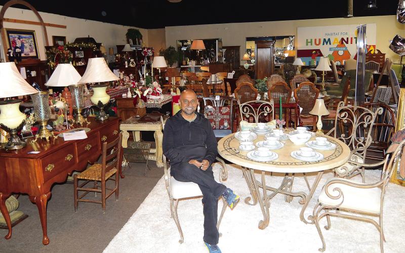 Putnam HFH Executive Director Murali Thiramul sits amidst the crowded showroom of furniture and housewares at the current Habitat Restore on Lake Oconee Parkway.