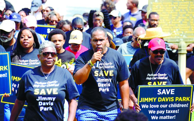 Georgia NAACP President Gerald Griggs (with microphone) leads the Save Jimmy Davis Park procession up the sidewalk Saturday morning at the Putnam County Courthouse in Eatonton.