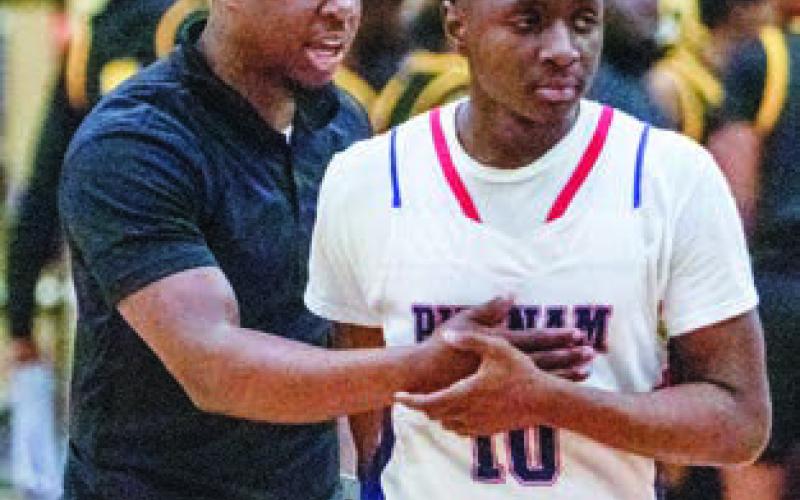 Putnam County assistant basketball coach Nick Banks (left) consoles junior guard Tamaud Woodson (right) after the team’s 68-66 loss to East Laurens in the Elite Eight last week. LANCE MCCURLEY/Staff