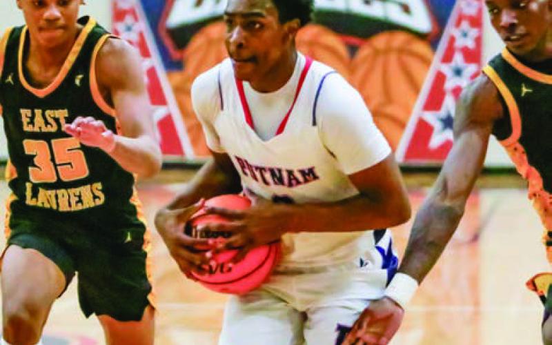 Putnam County junior Jmari Greene (3) drives past two East Laurens defenders into the paint. LANCE McCURLEY/Staff