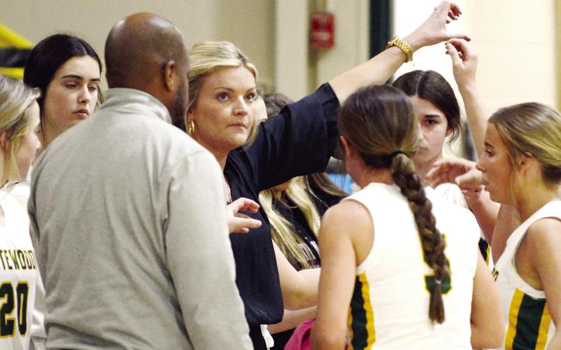 Gatewood head coach Jordan Walters steals a look at the scoreboard while counseling her Lady Gators during a recent game timeout. IAN TOCHER/Staff
