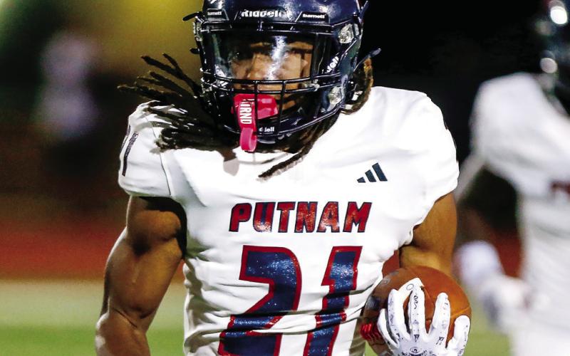 Putnam County sophomore running back Rasha Ellison Jr. (21) runs past Greene County defenders for a chunk gain. LANCE McCURLEY/Staff