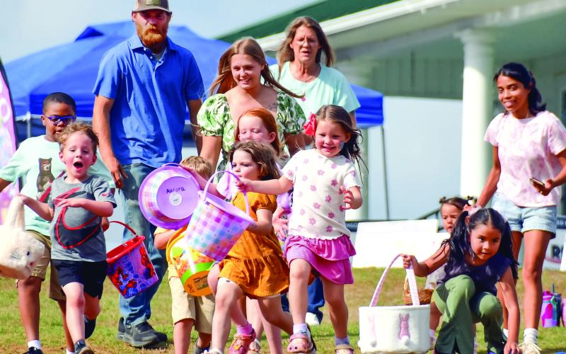 Families watch as children run to find Easter eggs. IAN TOCHER/Staff