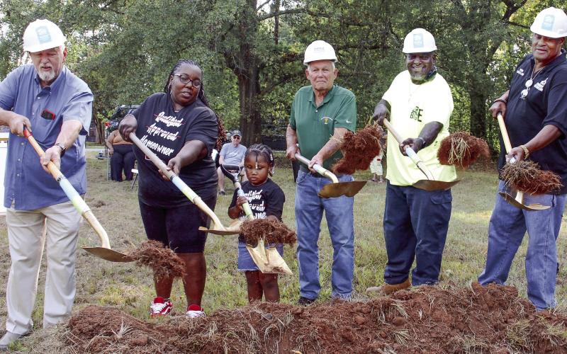 Helping to toss the ceremonial first shovelfuls of dirt alongside Standish Avenue was Putnam County Commission Chairman Bill Sharp (left), beside soon-to-be homeowner Tawana Ellison and her four-year-old daughter Gracelyn. IAN TOCHER/Staff
