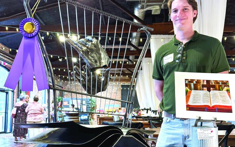 Inspired by an open-book photo of a Bible (right), Brian Danson created an all-metal sculpture featuring a pair of disembodied hands playing a harp that inspired a vote for him as the event’s Peoples’ Choice-winning artist. CONTRIBUTED
