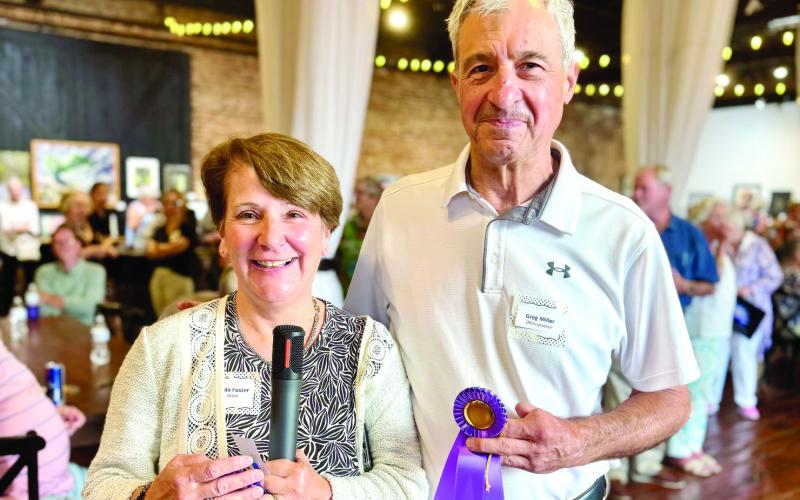 For the fourth-straight year, Dual Vision attendees voted Lake Country Photography Club board member Greg Miller as the Peoples’ Choice awardwinner photographer. Miller accepted the honor for his celestial image “Milky Way,” last Friday night from Artisans Village Board Secretary Linda Foster at Barrel 118 in Eatonton. IAN TOCHER/Staff