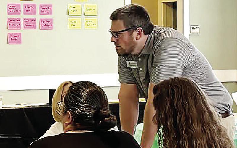 Regional Manager of Georgia Family Connection Partnership (GaFCP) Adam Swymer joins the discussion in one the small groups. EMME CLAUSE/Staff