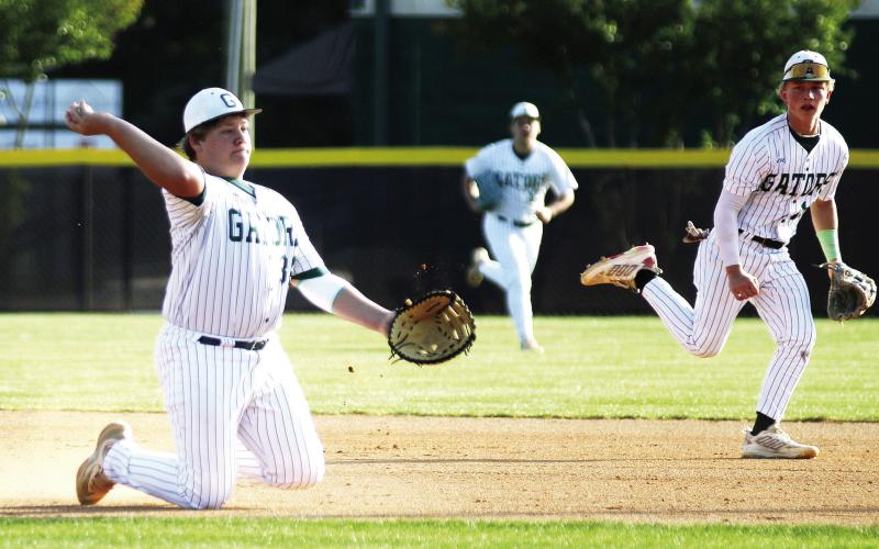 Gatewood’s Jayden Moss makes a play in the infield from his knees, attempting to throw out a baserunner at first base. TREY NORRIS/Staff