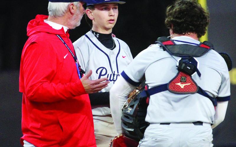 Putnam County head coach Stephen Phillips (left) talks with his pitcher and catcher during a break in play during the scrimmage against the Greyhounds. BRAD HARRISON/Staff
