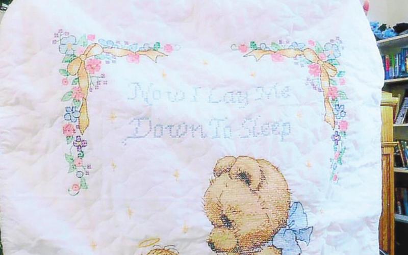 Carolyn Phillips shows off embroidered baby quilt. CONTRIBUTED
