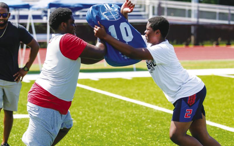 A Putnam County player (left) and a camper (right) work through a blocking drill during the camp.