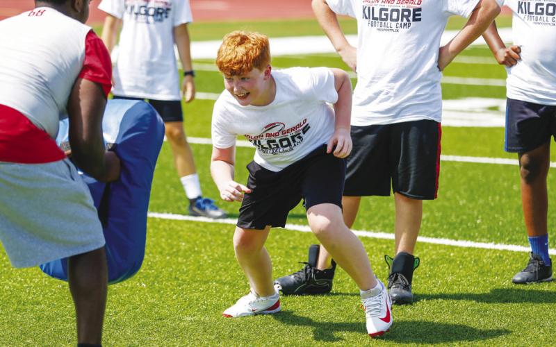 A camper gets into position before taking part in a blocking drill.