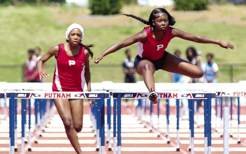 Putnam County’s Kamryn Manning and Malaya Robinson compete in the 300 hurdles event during the Region 4-AA meet in late April. TREY NORRIS/Staff