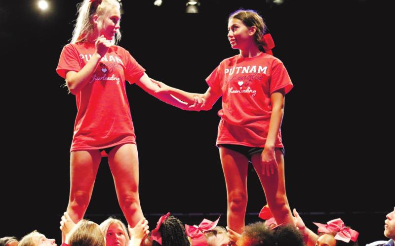 Two cheerleaders show they’re comfortable in the air.