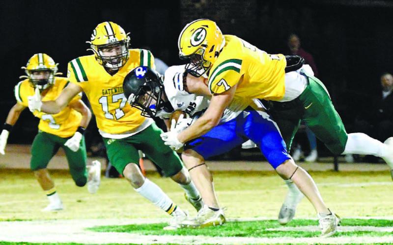 Gatewood defenders Sean Harvey (17) and Evan Bennett (7) converge on a Piedmont Academy ball carrier Oct. 28, with Ben Brannen (2) ready to join in if necessary at Sammons Field in Eatonton. DAWN SINCLAIR/Contributed
